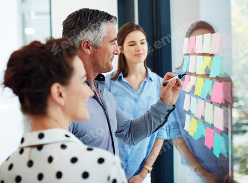 Preview: Cropped shot of three businesspeople working at a whiteboard