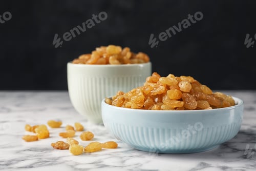 Preview: Bowls with raisins on marble table. Dried fruit as healthy snack