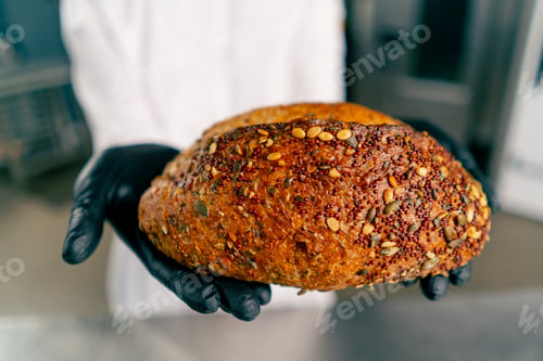 Preview: Close-up shot of freshly baked bread with crust and seeds that just came out of the bakery oven
