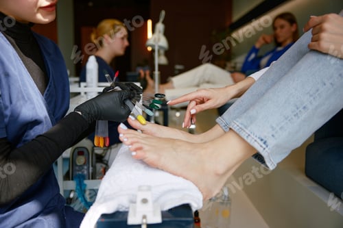 Preview: View from above on client choosing color for nail during pedicure