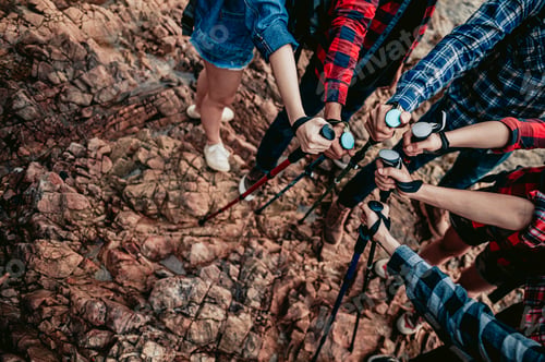 Preview: A group of hikers holding trekking sticks join together as a team.Teamwork , travel trekking