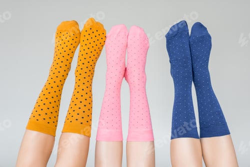 Preview: cropped shot of female legs in different colorful socks isolated on gray background