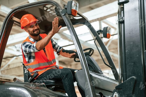 Preview: Driving the forklift. Industrial worker in wooden warehouse