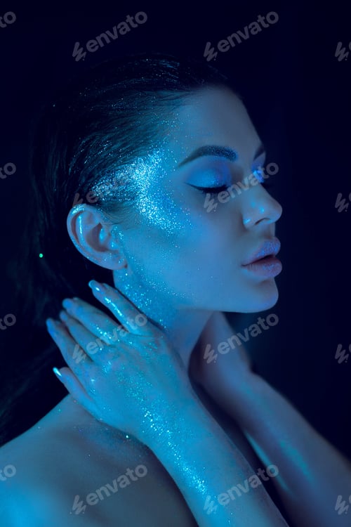Preview: Model poses with glitter highlights under blue lighting in a dark setting