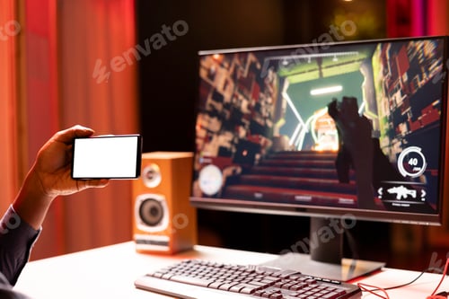 Preview: Gamer learning to play game by looking at online guide on mockup cellphone