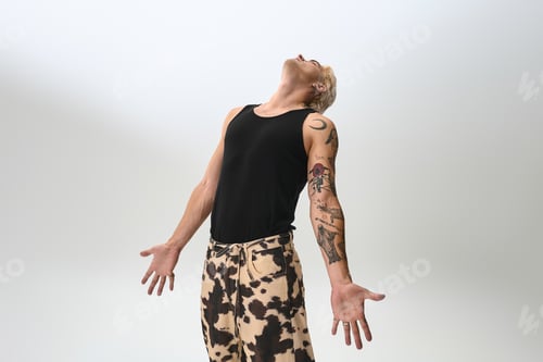 Preview: Stylish young man showcases a confident pose in modern fashion during a creative photoshoot