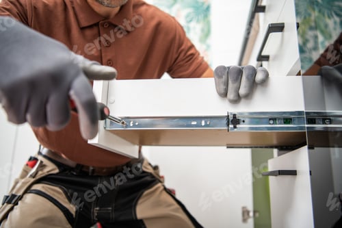 Preview: Skilled Worker Installs Cabinet Drawer With Precision in Modern Kitchen Setting During Daytime