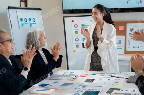 Preview: Businesswomen clapping hands during a meeting in an office, celebrating a successful presentation
