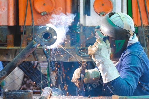 Preview: Welder is welding metal flange for using to material in oil pipeline systems maintenance work