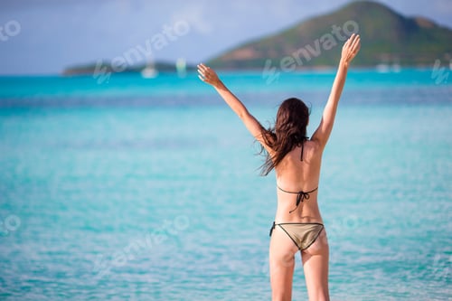 Preview: Young beautiful woman having fun on tropical seashore. Happy girl walking at white sand tropical