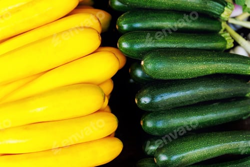 Vista previa: Close-up detail view row many fresh juicy green yellow local farmer's zucchini on street market