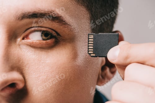 Preview: close up of man looking at chip near head isolated on grey