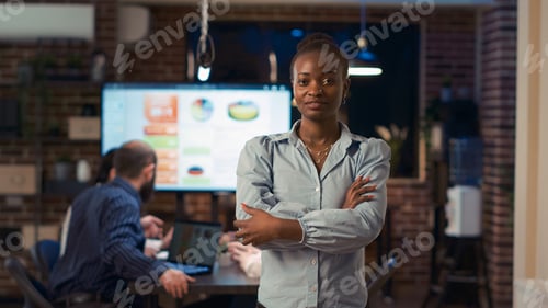 Preview: Smiling african american businesswoman crossing arms portrait, front view