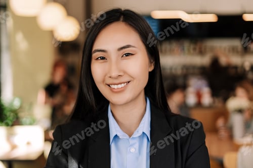 Preview: Young asian businesswoman smiling in busy coffee shop