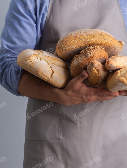Preview: Baker holding freshly baked bread with his hands, close up