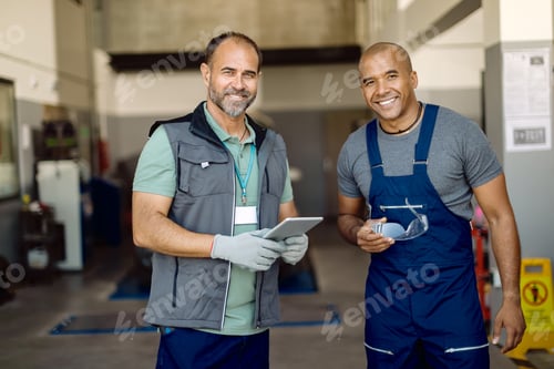 Preview: Happy auto mechanics working together in a workshop.