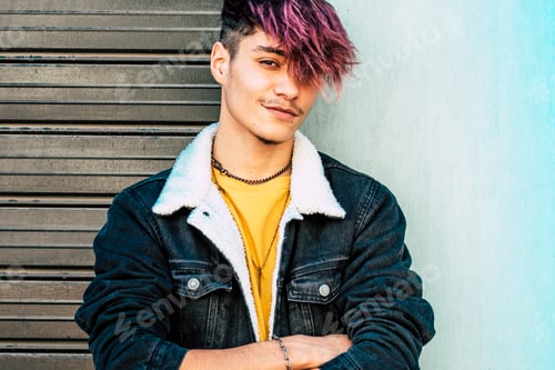 Preview: One young guy teenager standing against a wall and garage door looking on camera