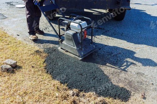 Preview: Paving lot repair involving manual tamping of asphalt using tamping a machines