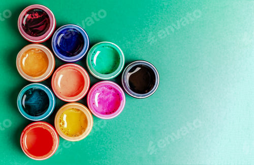Preview: Multicolored open jar with paint on a green background in the form of a pointer to the right