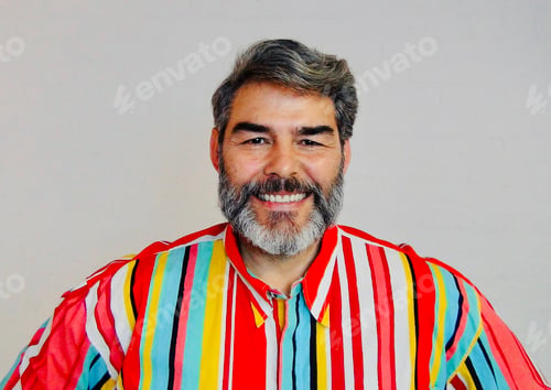 Preview: A friendly smiling handsome bearded middle aged man wearing a bright multi coloured shirt