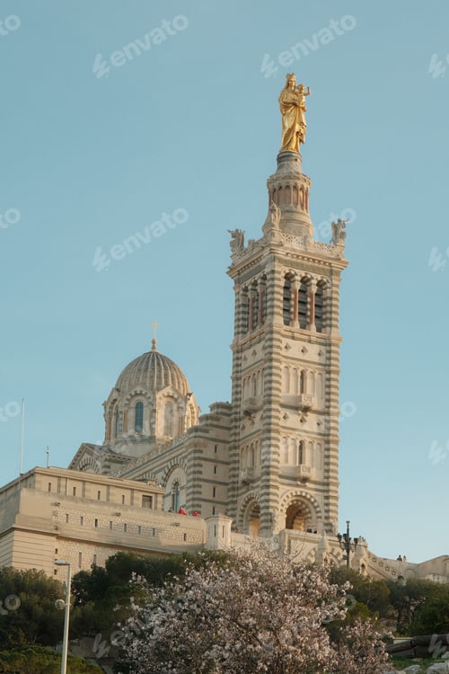 Preview: Grand building with a golden statue on top and a dome structure behind it