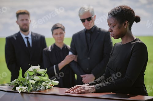 Preview: Young Black Woman Mourning Beside Coffin during Funeral Ceremony Outdoors