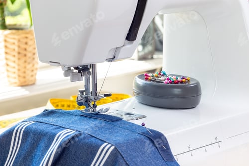 Preview: Sewing machine with striped blue white fabric and thread, home crafting or hobby, horizontal