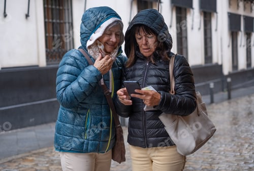 Preview: Two Women Looking at Smartphone in Urban Setting