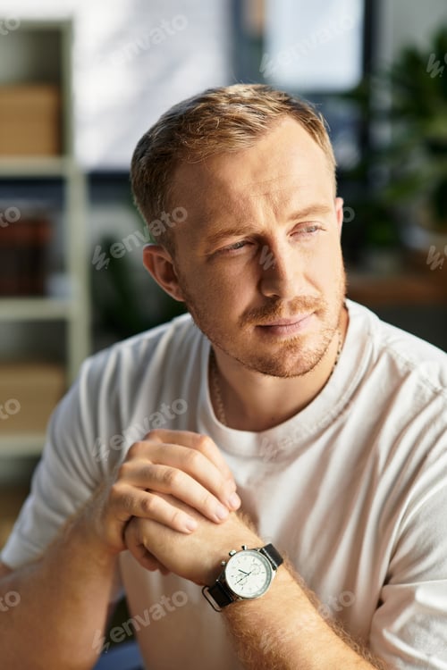 Preview: Handsome young businessman engaged in thoughtful reflection during office work hours