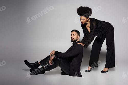 Preview: A passionate couple in stylish attire poses in a dramatic studio setting, exuding love and allure