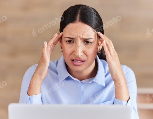 Preview: Young mixed race businesswoman looking stressed and tired confused while working on a laptop in an