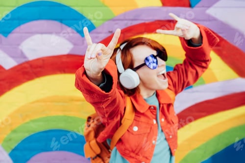Preview: Focus on rock and roll hand gesture of emotional stylish woman wears headphones, listening to music
