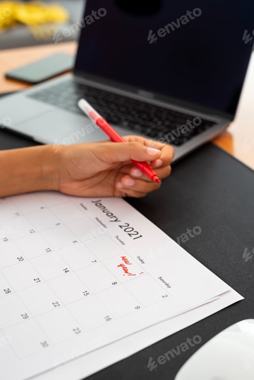 Preview: Woman marking January 1, 2021 on a calendar