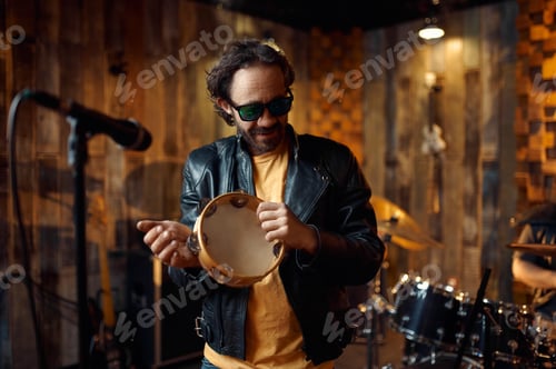 Preview: Male singer with tambourine at microphone on stage