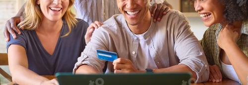 Preview: Close Up Of Multi-Cultural Group Of Friends With Laptop And Credit Card Booking Holiday Online