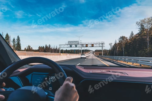 Preview: Man driving modern car from rear view on the highway. Hands on the steering wheel.