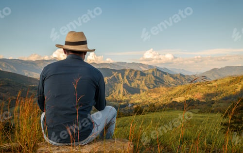 Preview: Man enjoying serene mountain landscape at sunset. Peaceful outdoor scene with person
