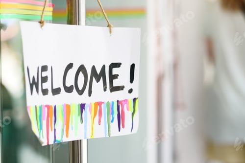 Preview: welcome hand written text on paper hanging on cafe door