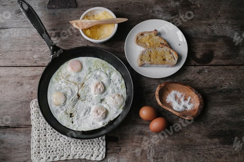 Preview: A dish of eggs, bread and sauce laid out on a table.