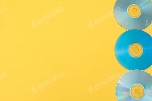 Preview: Line of three blue cds on yellow background with copy space