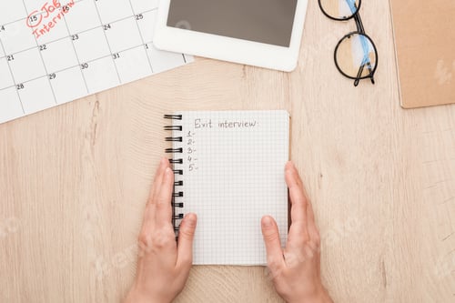 Preview: cropped view of recruiter holding notebook with exit interview lettering