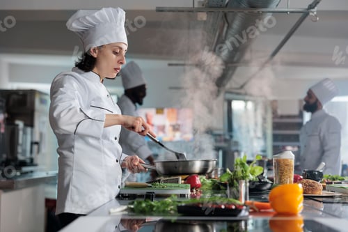 Preview: Head chef cooking gourmet dish for dinner service in restaurant professional kitchen.