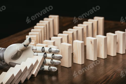 Preview: robotic hand preventing wooden blocks from falling on desk isolated on black