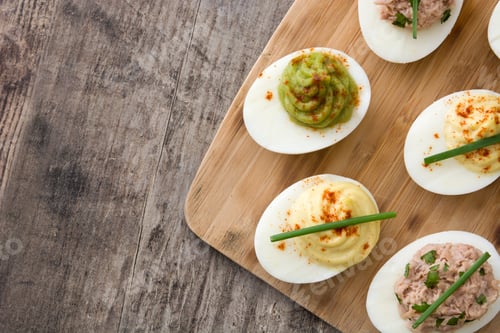 Preview: Assorted deviled eggs with toppings on a wooden board