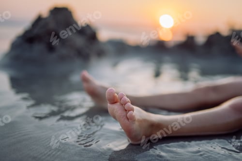 Preview: High angle view of childs legs in the sea.
