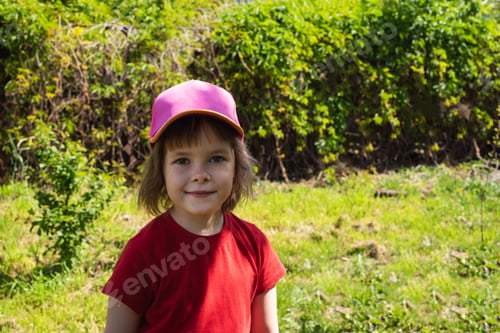 Preview: Happy child in a cap outdoors on a sunny warm day