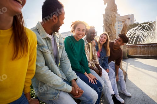 Preview: Side view of multiethnic group of Erasmus friends ganging out outdoors having fun.
