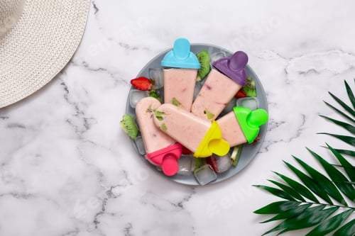 Preview: Homemade ice cream on a plate with ice and pieces of fruit and palm leaves