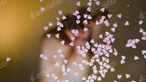Preview: Close-up of sprinkle in shape of hearts. Concept. Bottom view of transparent glass with multicolored