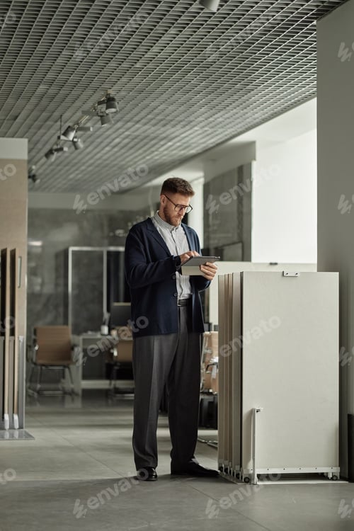 Preview: Caucasian Man Using Digital Tablet While Standing Indoors